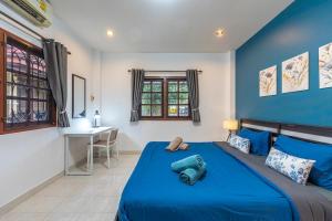 Dormitorio azul y blanco con cama y escritorio en Serenity Holiday Villa 1 D Karon Beach, en Karon Beach