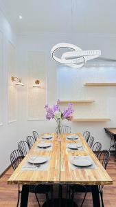ein Holztisch mit Stühlen und einer Vase mit lila Blumen in der Unterkunft Apartment in Jozsef krt 50 in Budapest