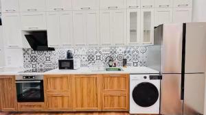 eine Küche mit weißen Schränken und einem weißen Kühlschrank in der Unterkunft Apartment in Jozsef krt 50 in Budapest