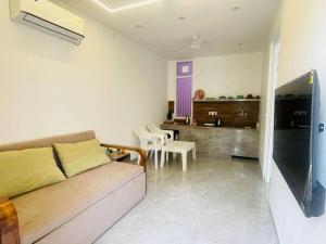 a living room with a couch and a kitchen at PUNTUSH By The StayCationer in Dehradun +10 photos