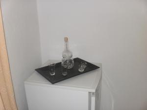 Una mesa blanca con una botella y vasos. en Studios Kallirachi, en Skala Kallirakhis