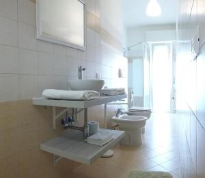a white bathroom with a sink and a toilet at Casa Vacanze Le Due Palme in Miglianico