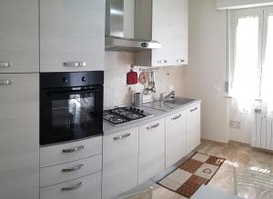 a kitchen with white cabinets and a black stove top oven at Casa Vacanze Le Due Palme in Miglianico