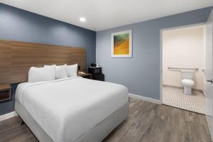 a hotel room with a bed and a bathroom at Days Inn by Wyndham Arroyo Grande Pismo Beach in Arroyo Grande