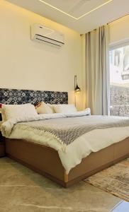 a bedroom with a large bed with a window at PUNTUSH By The StayCationer in Dehradun