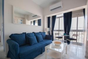 ein Wohnzimmer mit einem blauen Sofa und einem Tisch in der Unterkunft Apartment Altavista in Cádiz