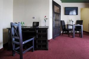 an office with a desk with a chair and a table at Hotel Kasztel in Rzezawa