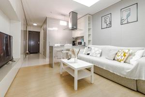 アスタナにあるHighvill Modern View идеально для туристаの白いソファとテーブルのあるリビングルーム