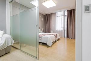 アスタナにあるHighvill Modern View идеально для туристаのベッドルーム1室(ベッドにつながるガラスドア付)