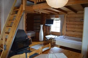 a living room with a fireplace and a bunk bed at Peurasuvanto Mökit & Camping in Peurasuvanto