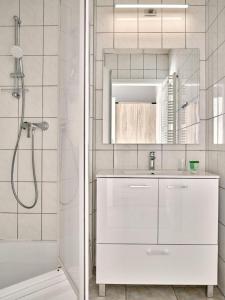 a white bathroom with a shower and a sink at Pałac Potockich w Będlewie in Będlewo