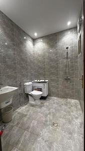 a bathroom with a toilet and a sink and a shower at شقة فندقية بمجمع هوازن السكني in Ash Sharāʼi‘