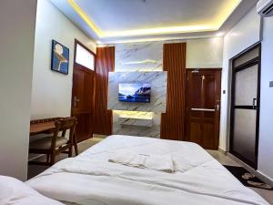 a bedroom with a bed and a desk in it at GEMSON HOMEs in Dar es Salaam