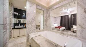 une grande salle de bain avec baignoire et une chambre dans l'établissement Hotel Floce, à Pup'yŏng-dong 220 autres photos