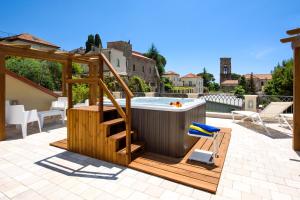 a hot tub on a patio with a wooden deck at Ravello House in Ravello