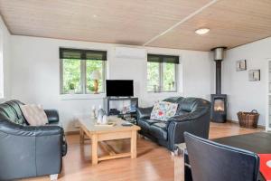 Una sala de estar con muebles de cuero y chimenea. en G125-Lemvig-Bellisvej-25, en Lemvig