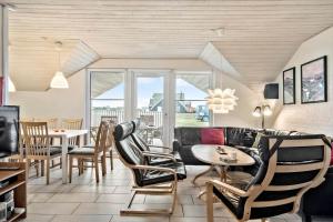 a living room with a couch and a table and chairs at 302-Harboore-Fourmivej-74 in Harboør