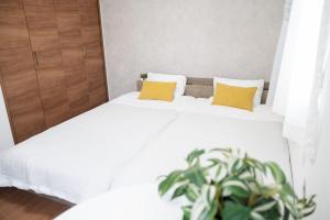 a bedroom with two beds with yellow pillows and a plant at The Emu Park Tsushima in Tsushima