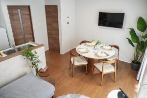 a dining room with a table and chairs in a living room at The Emu Park Tsushima in Tsushima