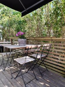 a table and chairs on a deck with an umbrella at PaprikanTiny House in Uppsala