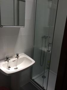 a bathroom with a sink and a glass shower at Private Room in Old Town in Viana do Castelo