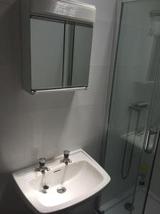 a bathroom with a white sink and a shower at Private Room in Old Town in Viana do Castelo