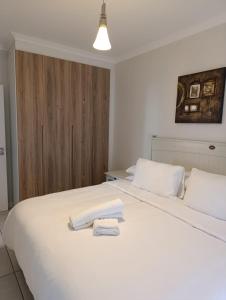 a white bed with two towels on top of it at Luxury Apartment at The Blyde Crystal Lagoon in Pretoria
