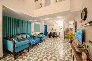 a living room with two blue couches and a table at HideAway 2BHK Duplex Villa, North Goa (STU) in Mapusa