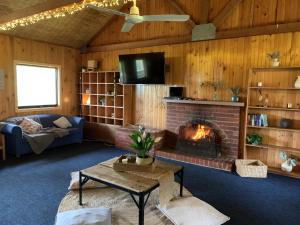 a living room with a fireplace and a couch at Iluka Retreat Glamping Village & Group Lodge Accommodation in Red Hill South