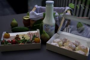 two boxes of food and a bottle of milk on a table at Vineyard Escape Herbersteinova klet in Juršinci