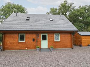 a small wooden building with a white door at Bradan Lodge in Dalmally