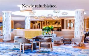 un vestíbulo de un hotel con sillas y mesa en Southern Sun Rosebank, Johannesburg, en Johannesburgo