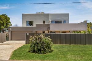 a house with a fence in front of it at Beachside Retreat in Cowes