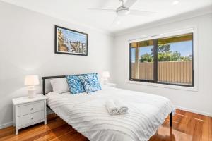 a white bedroom with a bed and a window at Beachside Retreat in Cowes