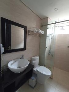 a bathroom with a sink and a toilet and a mirror at Orchids Ocean Hotel in Da Nang