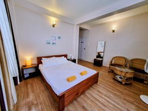 een slaapkamer met een groot bed en een stoel bij Breeze Vale Homestay in Shillong