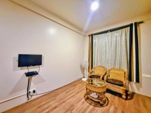 a living room with two chairs and a window at Breeze Vale Homestay in Shillong