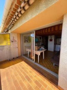 ein Wohnzimmer mit einer großen Glastür und einem Tisch in der Unterkunft charmant studio Mezzanine vue mer,près du port in La Londe-les-Maures