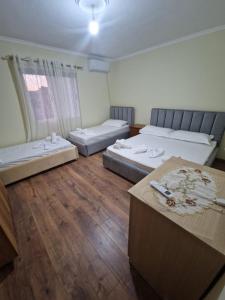 a large room with two beds and a table at Central Apart Permet in Përmet