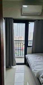 a bedroom with a bed and a large window at City Escape in Manila +14 photos