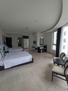 a bedroom with two beds and a table and a desk at Orchids Ocean Hotel in Da Nang +23 photos