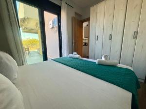 a bedroom with a white bed with a green blanket at Chloe Stay Complex by Horizon Homes in Orfánion
