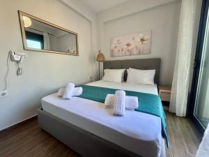 a hotel room with two beds and a mirror at Chloe Stay Complex by Horizon Homes in Orfánion