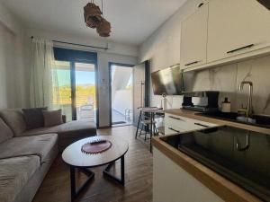 a kitchen and living room with a couch and a table at Chloe Stay Complex by Horizon Homes in Orfánion
