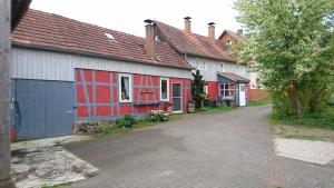 uma fila de casas com vermelho e branco em Ferienhaus vom Bahratal em Hausen