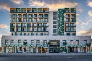 Un gran edificio con palmeras delante. en Stylish Studio in One on Albert, en Hout Bay