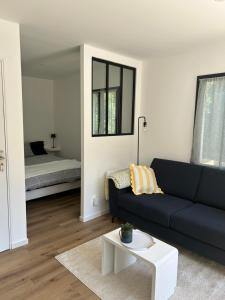 a living room with a blue couch and a white table at Studio calme avec terrasse proche centre-ville in Niort