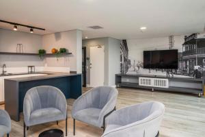 Sala de estar con 3 sillas y TV en Stylish Studio in One on Albert, en Hout Bay