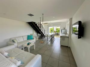 a living room with a white couch and a kitchen at Mas de l Aire in Corneilla-del-Vercol