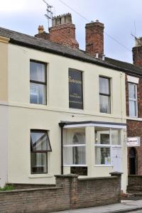 un viejo edificio de ladrillo con un cartel. en The Bunkroom, en Chester